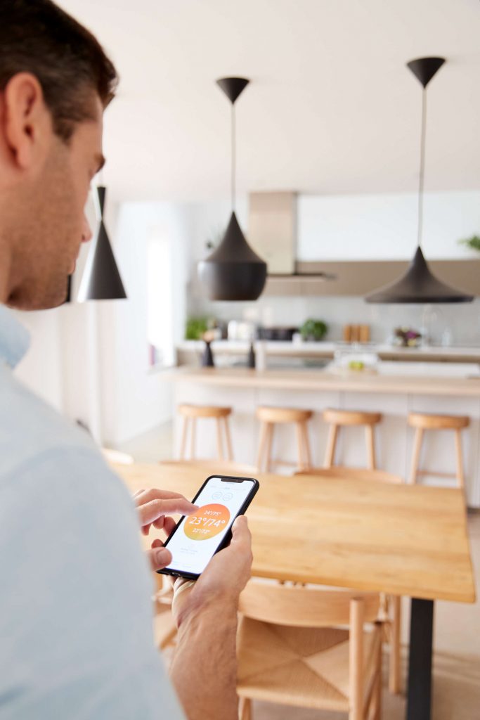 man-using-app-on-smart-phone-to-control-central-he-79H3GA6.jpg